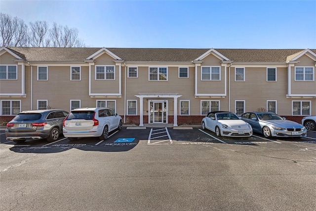 view of property featuring brick siding and uncovered parking