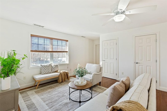 living area featuring ceiling fan, wood finished floors, visible vents, and baseboards