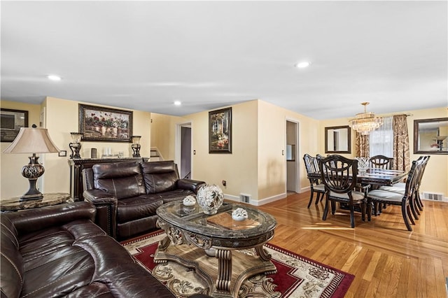 living area featuring recessed lighting, visible vents, wood finished floors, baseboards, and stairs