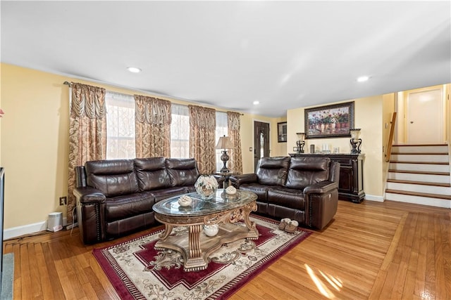 living room featuring light wood finished floors, stairs, baseboards, and recessed lighting