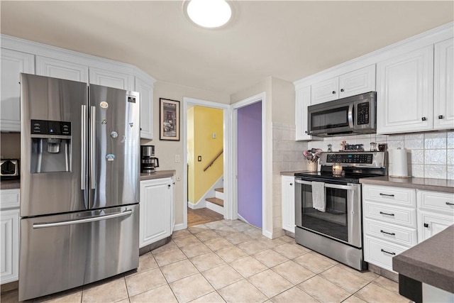 kitchen featuring dark countertops, white cabinetry, and stainless steel appliances