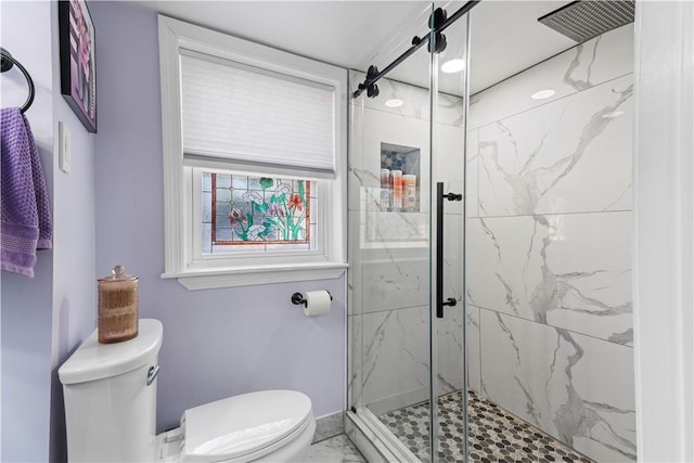 bathroom featuring marble finish floor, a marble finish shower, and toilet