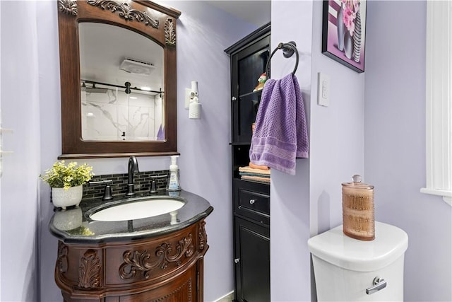 bathroom with toilet, backsplash, and vanity