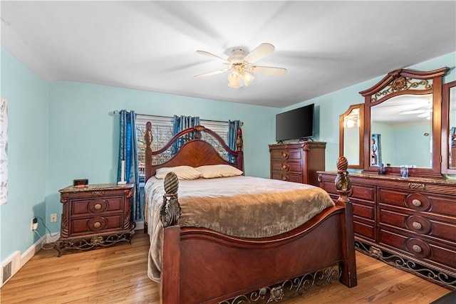 bedroom featuring ceiling fan, light wood-type flooring, visible vents, and baseboards