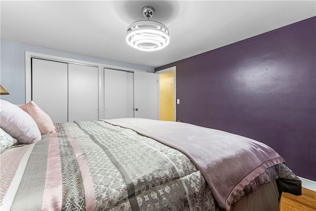 bedroom with two closets and wood finished floors