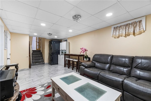 living area featuring recessed lighting, a paneled ceiling, and stairway