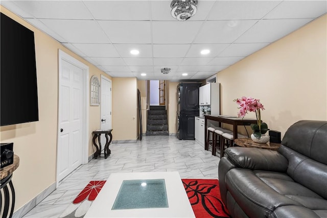 living area with a paneled ceiling, marble finish floor, stairway, and recessed lighting