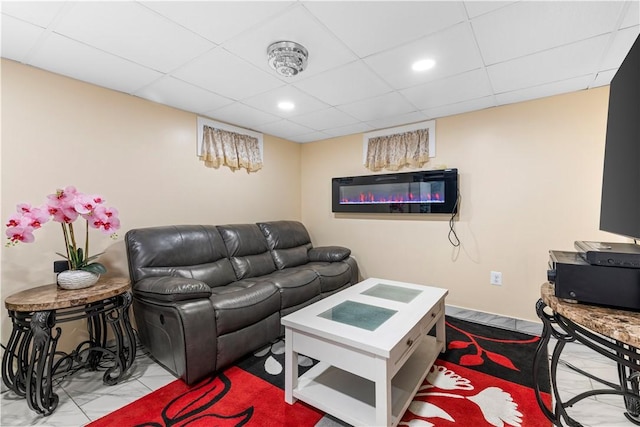 living area featuring marble finish floor, a paneled ceiling, and recessed lighting