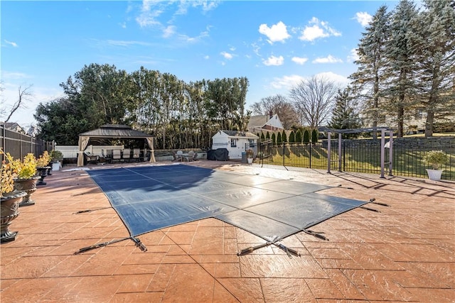 view of swimming pool with fence and a gazebo