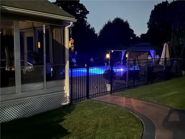 view of swimming pool with a yard, fence, a sunroom, and a fenced in pool