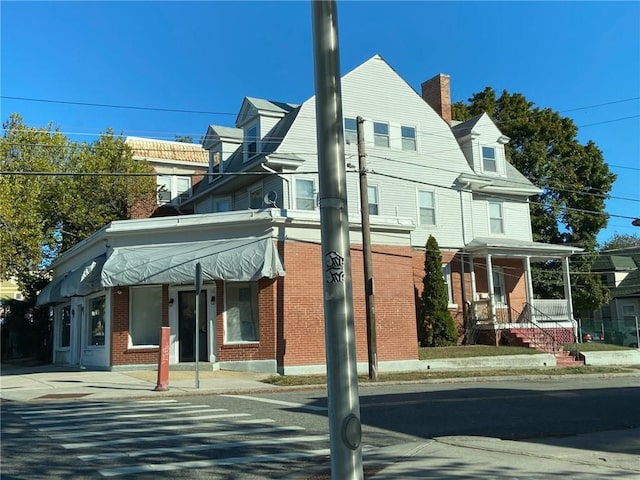 exterior space with brick siding and a chimney