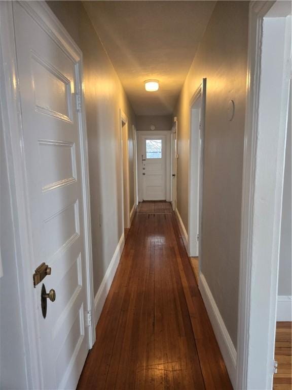 corridor with baseboards and dark wood-style flooring