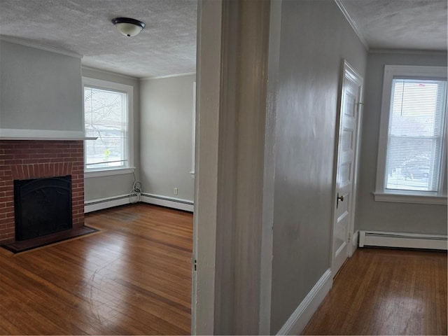 interior space with a baseboard heating unit, a brick fireplace, crown molding, and wood finished floors