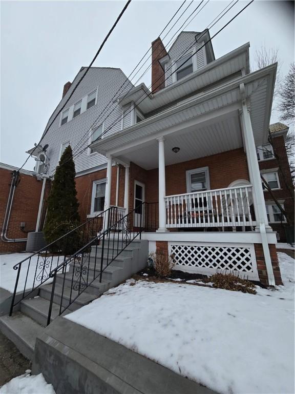 view of front of property with covered porch and brick siding