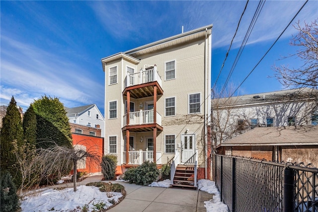 view of front facade featuring fence and a balcony