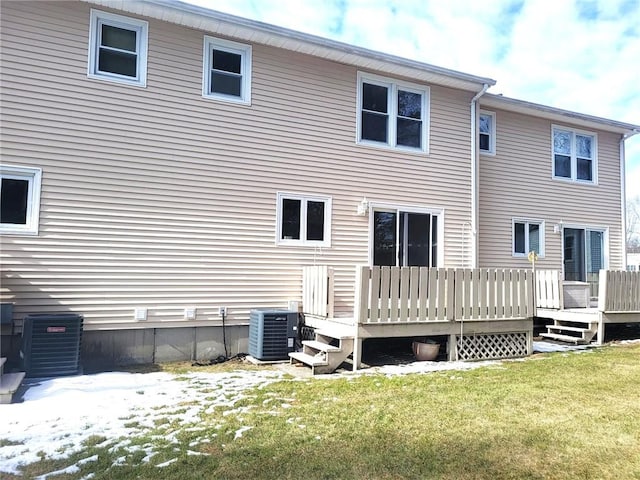 rear view of property featuring cooling unit, a yard, and a wooden deck