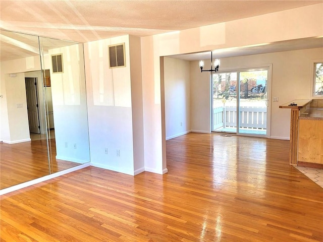 interior space with wood finished floors and visible vents