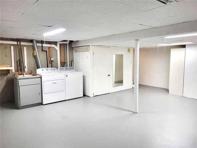 finished basement with washing machine and dryer and a sink