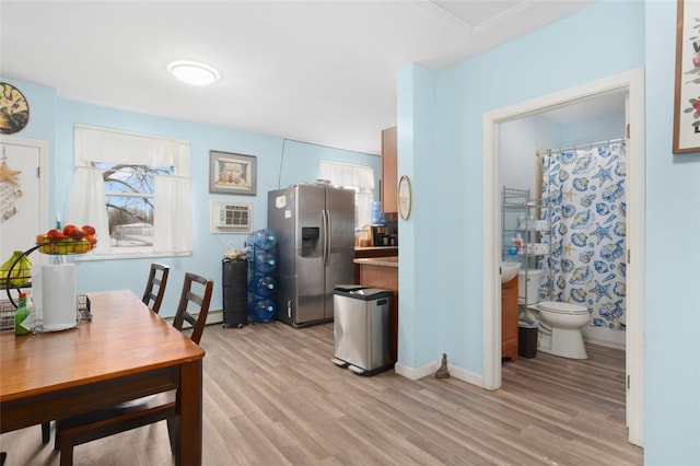 kitchen featuring light wood finished floors, stainless steel fridge, and baseboards