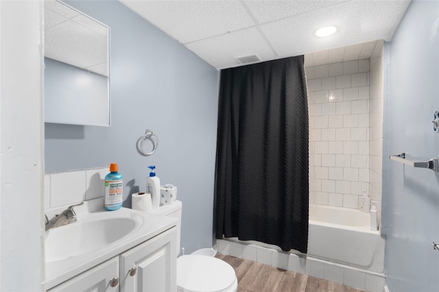 bathroom featuring visible vents, toilet, wood finished floors, shower / bath combination with curtain, and vanity