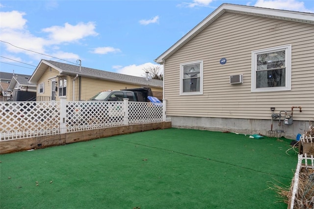 exterior space with a wall mounted air conditioner and fence