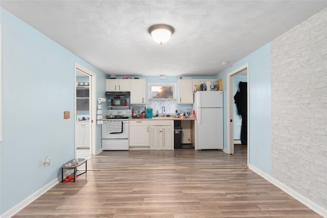 kitchen with light wood-type flooring, white appliances, white cabinets, and a sink