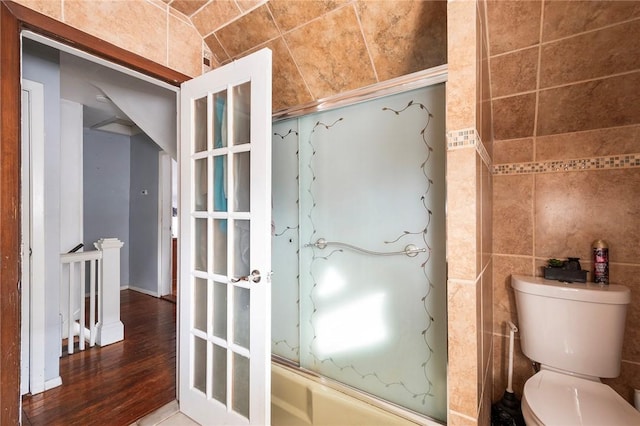 bathroom featuring toilet, tile walls, and wood finished floors