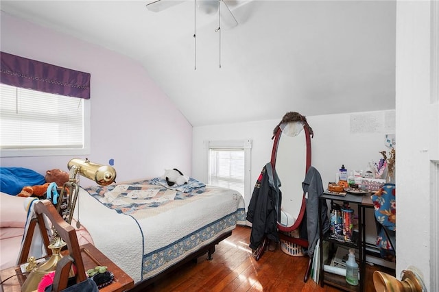 bedroom with ceiling fan, vaulted ceiling, and wood finished floors