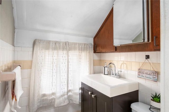 kitchen featuring tile walls, lofted ceiling, light countertops, decorative backsplash, and a sink