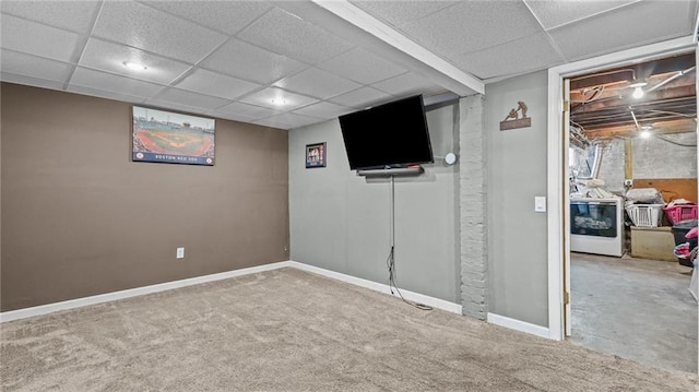 finished below grade area with carpet floors, washer / dryer, a drop ceiling, and baseboards