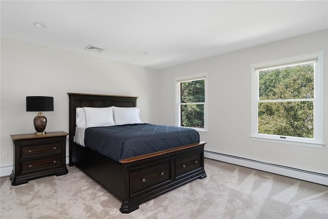 bedroom with light carpet, visible vents, and a baseboard heating unit