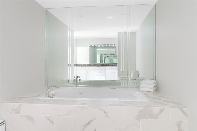 full bath featuring a garden tub and vanity