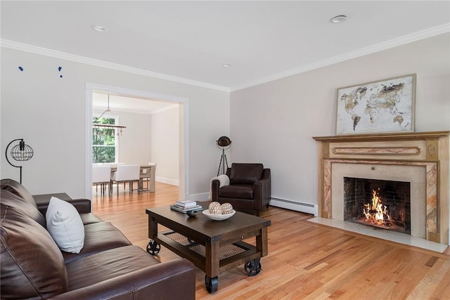 living area featuring a fireplace, crown molding, light wood finished floors, and baseboard heating