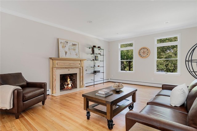 living area with light wood-type flooring, a high end fireplace, a baseboard heating unit, and crown molding