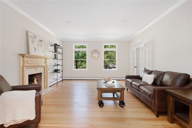 living room with light wood-type flooring, a baseboard heating unit, crown molding, and a high end fireplace