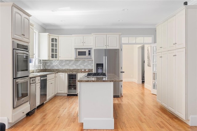 kitchen featuring white cabinets, beverage cooler, a kitchen island, and stainless steel appliances