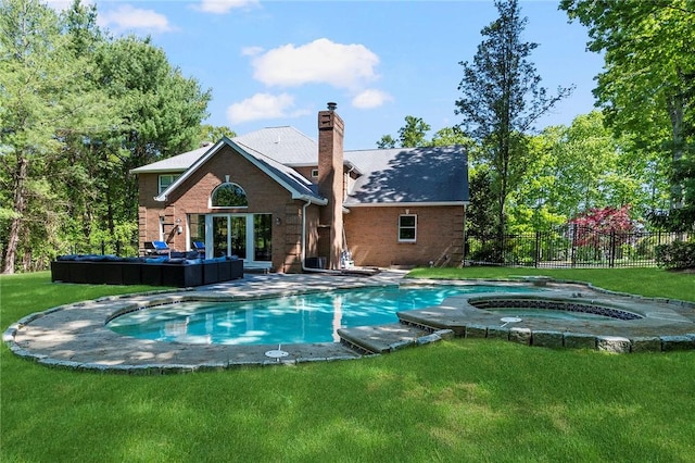 view of pool featuring a yard, fence, a fenced in pool, and an in ground hot tub