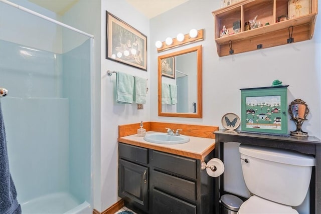 full bathroom featuring a stall shower, vanity, and toilet