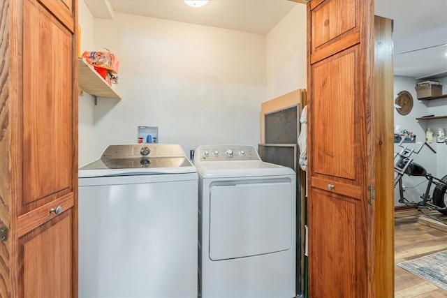 washroom featuring light wood-type flooring, laundry area, and washer and clothes dryer