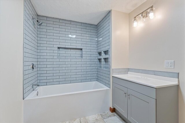 bathroom with a textured ceiling, shower / bathing tub combination, and vanity