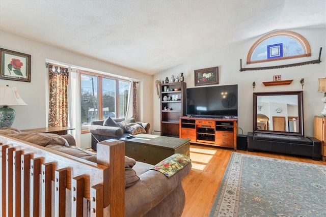 living room with light wood-style flooring, a baseboard heating unit, and vaulted ceiling