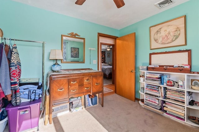 interior space featuring a ceiling fan, light colored carpet, and visible vents