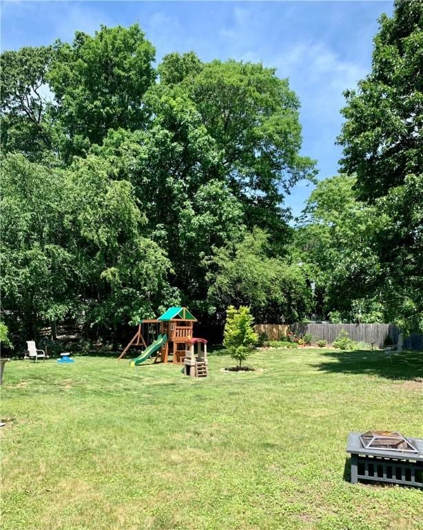 view of yard featuring an outdoor fire pit, fence, and a playground