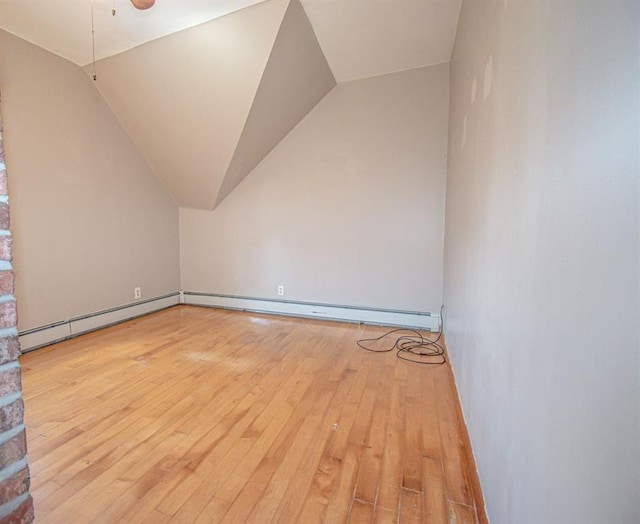 bonus room featuring vaulted ceiling, baseboard heating, light wood-type flooring, and a baseboard radiator