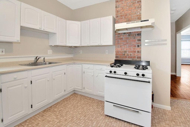 kitchen with light countertops, gas range gas stove, white cabinetry, and under cabinet range hood