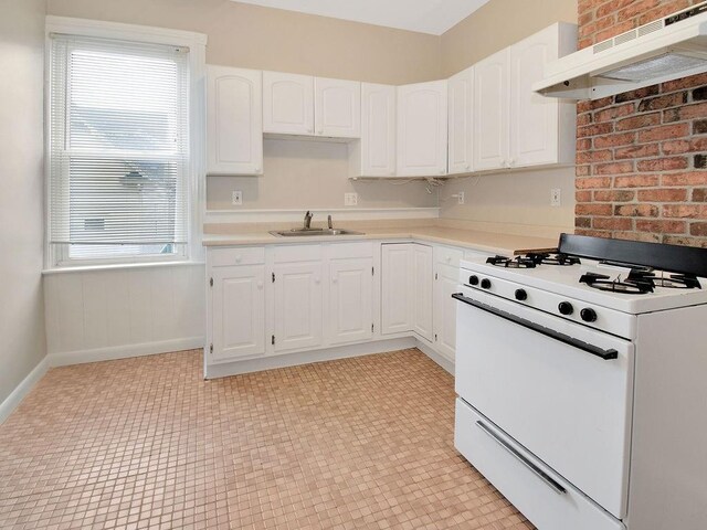 kitchen featuring light countertops, white cabinetry, white range with gas cooktop, a sink, and under cabinet range hood