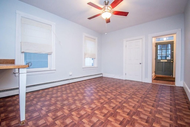 empty room with a ceiling fan, a baseboard radiator, and baseboards