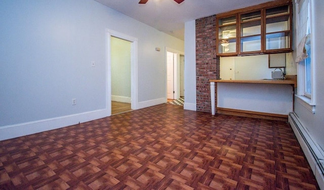 interior space with ceiling fan, baseboard heating, and baseboards