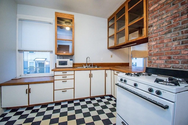 kitchen featuring dark floors, white appliances, white cabinets, and plenty of natural light