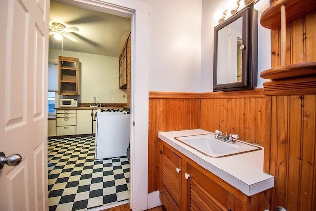 bathroom featuring ceiling fan, a wainscoted wall, wood walls, vanity, and tile patterned floors